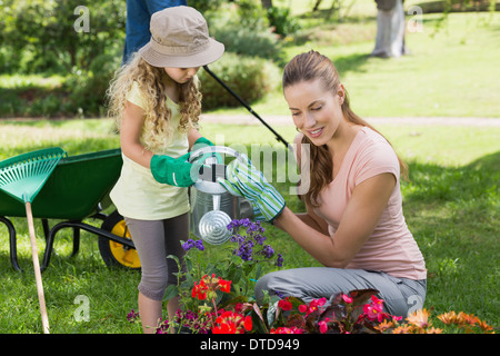 Mother with daughter watering plants Stock Photo