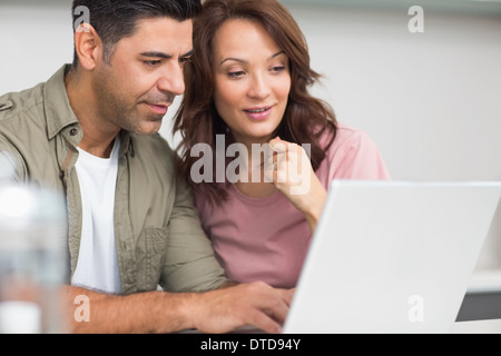 Couple using laptop in the kitchen Stock Photo