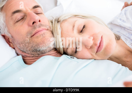 Loving mature couple sleeping in bed Stock Photo