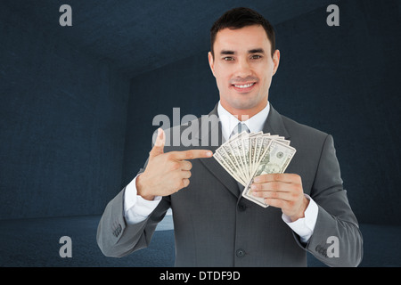 Composite image of businessman pointing at bank notes in his hand Stock Photo