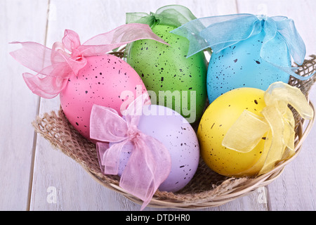 Easter eggs in a basket on a light background Stock Photo