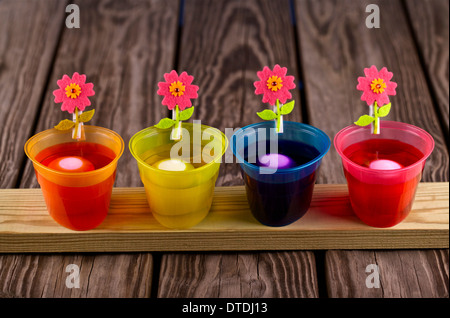 Easter eggs being dyed in several bowls Stock Photo