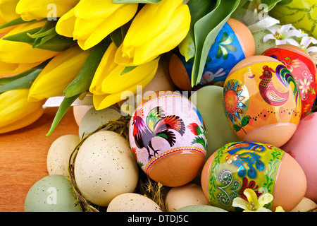 Easter eggs and yellow tulips on wooden background Stock Photo