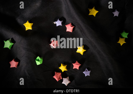 Multicolor small origami stars on back satin Stock Photo