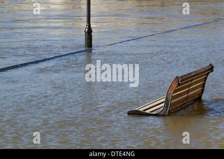 Staines Surrey, UK. 16th February 2014. A public bench partially submerged in water. Rising water levels continue along parts of the River Thames following unprecedented bad weather  bringing misery to residents despite improving sunny weather over the weekend © amer ghazzal/Alamy Live News Credit:  amer ghazzal/Alamy Live News Stock Photo