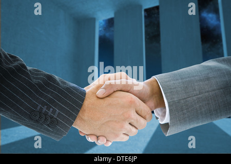 Composite image of business handshake against light shining Stock Photo