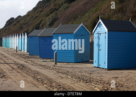 dislodged blue beach huts facing the wrong way and out of line after recent storms windy bad weather at Bournemouth, Dorset UK in February Stock Photo