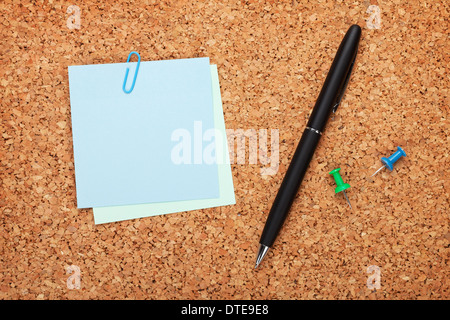 Blank postit notes on cork notice board with pen Stock Photo