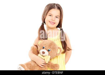 Cute little girl in yellow dress holding a teddy bear Stock Photo