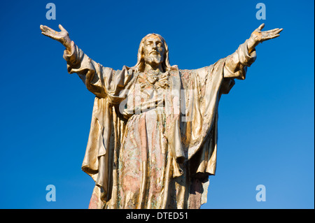 Weathered statue of Jesus Christ with outstretched arms. Stock Photo