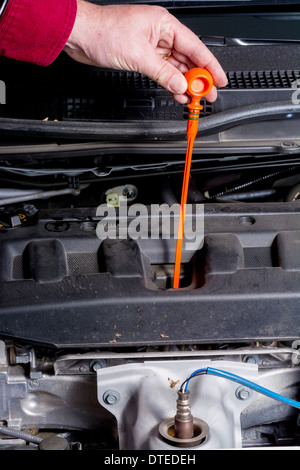 Hand pulling dipstick checking car engine oil Stock Photo - Alamy