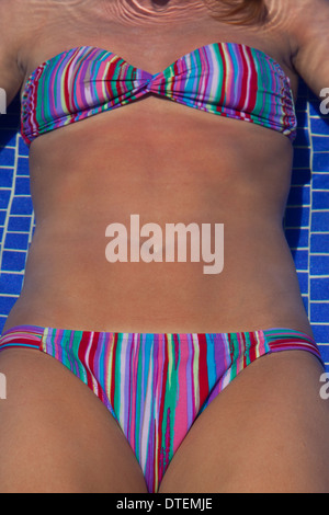 Mid section of young woman wearing swimming costume Stock Photo