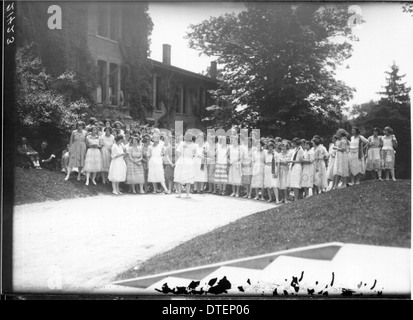 This 1922 photograph from Western College shows students participating in Tree Day, an event that highlights the college's commitment to women's education and outdoor activities. The image captures the students in an open-air setting, engaging in various activities. Stock Photo