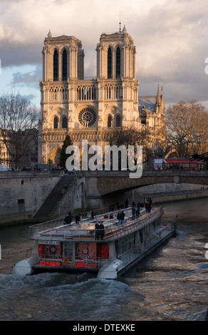 Notre Dame cathedral and Bateau Mouche seen from the river Seine on a late winter afternoon Stock Photo