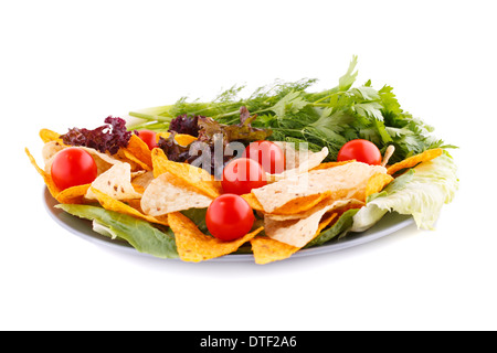 Nachos, cherry tomatoes, lettuce, herbs in plate on white background. Stock Photo