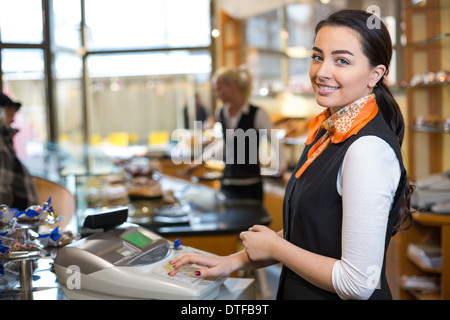 Shopkeeper and saleswoman at cash register or checkout counter Stock Photo