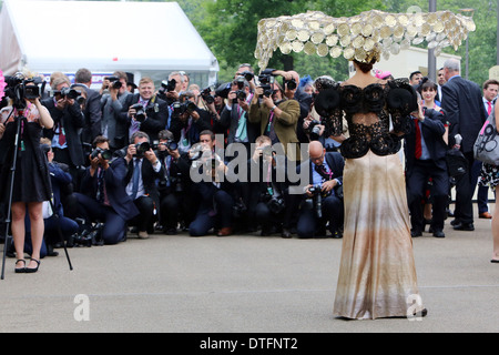 Ascot, United Kingdom, elegantly dressed woman with hat posing against a series photographer Stock Photo