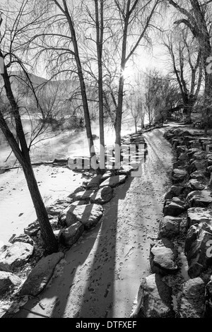 Black & white view of snow and ice on a footpath along the Arkansas River which runs through historic district of Salida, CO Stock Photo