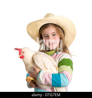 Blond kid girl farmer holding white hen on arms with cowboy hat Stock Photo