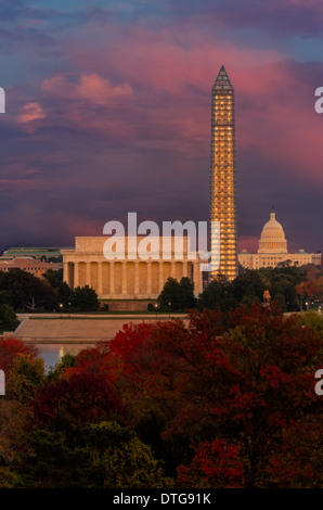 A view from across the Potomac River to the Lincoln Memorial, the Washington Monument and the Capitol Building during autumn and sunset. The peak fall foliage adds beautiful colors and the Washington Monument although covered with scaffolding due to repairs being done due to damages from the 2010 Earthquake, looks very elegant when illuminated at sundown. Stock Photo