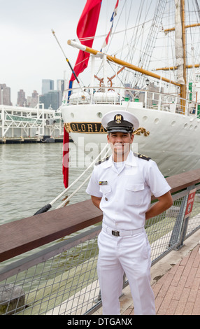 Cadet J. Giraldo poses in front of the Columbian Buque Escuela A.R.C. Gloria tall ship. Gloria sailed in to New York City for Fleet Week. Stock Photo