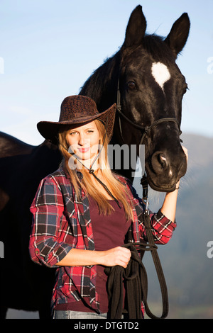 Young woman with a black Hanoverian horse, North Tyrol, Austria Stock Photo