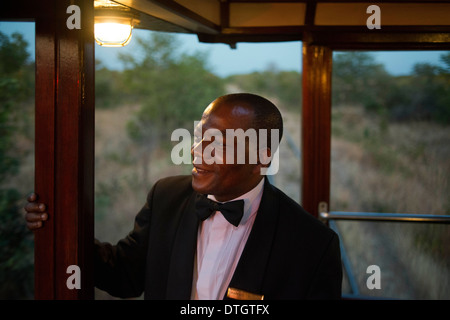 One of the railway workers of the Livingstone Express luxury train. Fine dining is redefined when the venue is the dining car Stock Photo