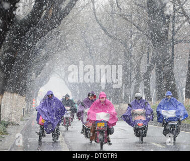 Suzhou, China's Jiangsu Province. 18th Feb, 2014. People ride in the snow on a street of Suzhou, east China's Jiangsu Province, Feb. 18, 2014. The southern part of China witnessed snowfall on Tuesday. Credit:  Hang Xingwei/Xinhua/Alamy Live News Stock Photo