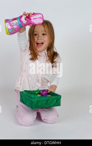 Girl is happy about an Easter basket and a chocolate Easter bunny Stock Photo