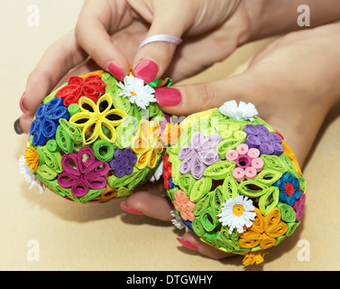 Woman holding in the hands two easter eggs made of colored paper. Stock Photo