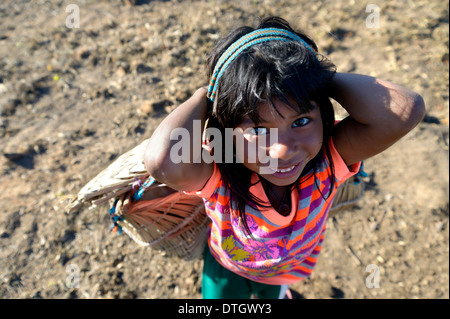 Girl carrying a traditional basket on her back in a village of the Xavantes people, Nova Vida near the mission of Sangradouro Stock Photo