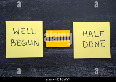 interpretation of famous Aristotle quote 'Well begun is half done' handwritten on sticker notes Stock Photo