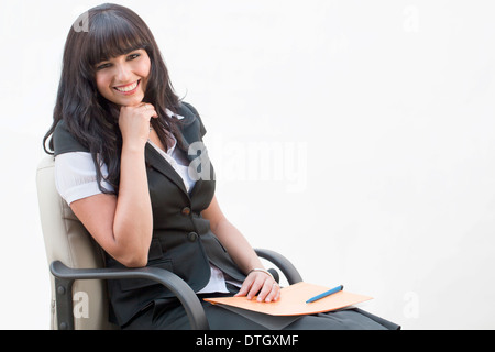 Business woman sitting in an office chair, Germany Stock Photo