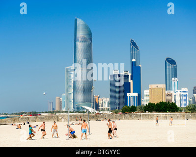 Volleyball game on Corniche beach with skyline in Abu Dhabi United Arab emirates Stock Photo