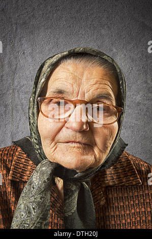 Portrait of an old woman on a vintage background, dreaming the past. Soft focus. Stock Photo