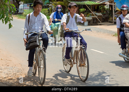 School children on bikes in rural traffic in Tay Ninh, Vietnam Stock Photo