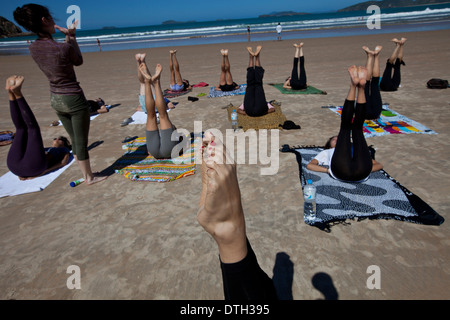 Young people practicing yoga at Geriba beach, Armacao de Buzios, Rio de Janeiro State, Brazil. Stock Photo