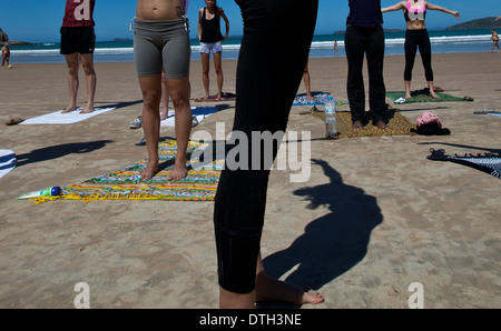 Young people practicing yoga at Geriba beach, Armacao de Buzios, Rio de Janeiro State, Brazil. Stock Photo