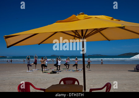 Young people practicing yoga at Geriba beach, Armacao de Buzios, Rio de Janeiro State, Brazil. Stock Photo