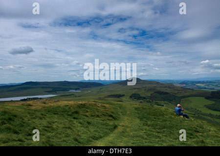 A walker enjoying the view, looking towards West Lomond from East Lomond above the village of Falkland, Fife Stock Photo