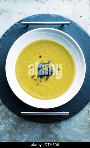 Split peas soup with garnish in white bowl Stock Photo