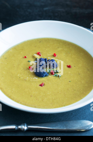 Split peas soup with garnish in white bowl Stock Photo