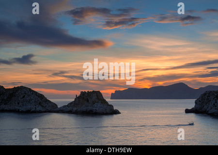 Malgrat isles and fishing boat at dusk. Cap des Llamp cape behind. Calvià/Andrtax area. Majorca, Balearic islands, Spain Stock Photo