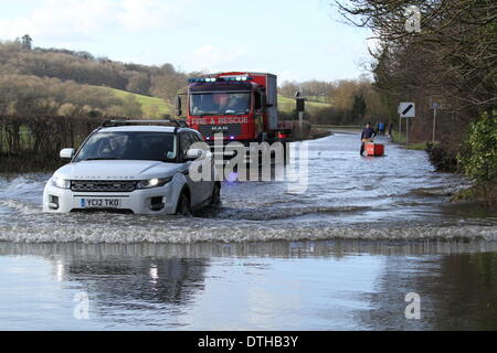 Egham, Surrey, UK. 17th February 2014. Flood Scenes From Egham, Surrey  A car negotiates floodwaters as West Yorkshire Fire And Rescue Service Set up pumps to clear the A308 Windsor Road near Runnymede. Stock Photo