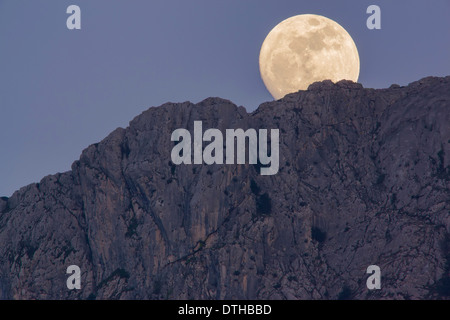 Real full moon rising over Serra d'Alfàbia mountain at dusk. Tramuntana hills, Sóller area, Majorca, Balearic islands, Spain