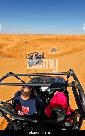 Tourists in Dubai desert driving buggy. Stock Photo