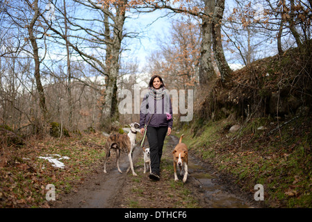 Young woman walking in nature with dogs Stock Photo