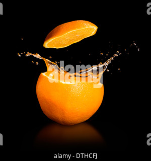 Orange juice splashing isolated on black Stock Photo