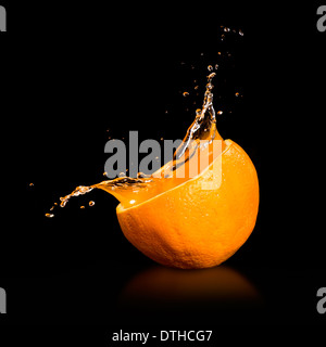 Orange juice splashing isolated on black Stock Photo
