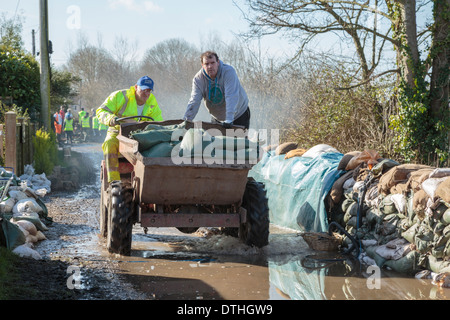 Volunteer aid workers help distribute sandbags in the flooded village of Moorland on the Somerset Levels. Stock Photo